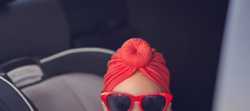 Kind zit met een gepolariseerde zonnebril in de auto