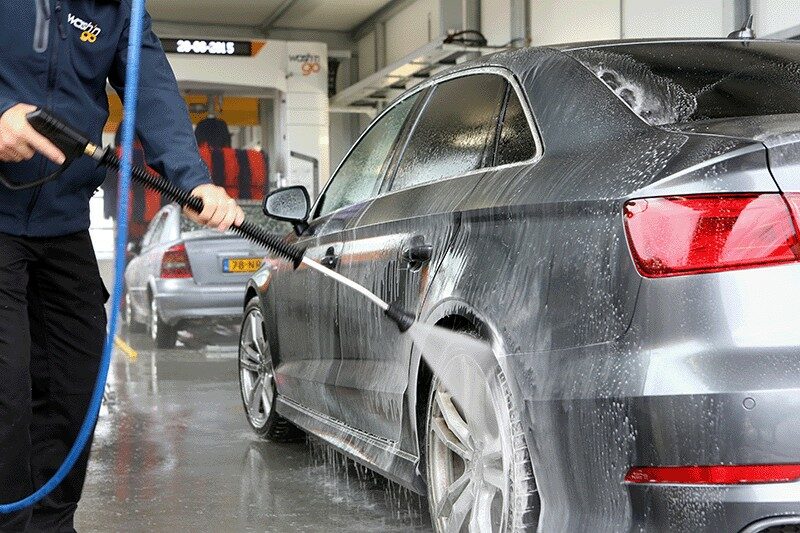 Auto wordt gewassen met een hogedrukspuit