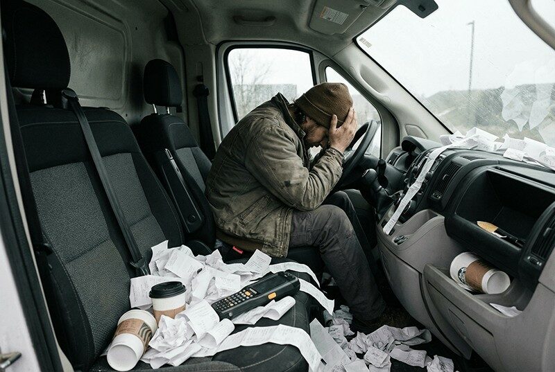 Een koerier tussen de bonnetjes in zijn bestelbus