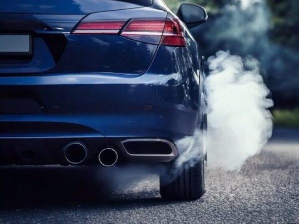 Firefly een donkerblauw auto gezien van achter waarvan rook uit de uitlaat komt, gezien vanaf straat Uitlaatgassen auto